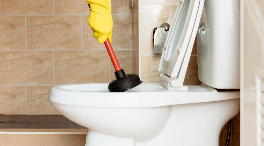 man using a plunger to unclog toilet - Elizabeth Drain and Plumbing Services | Elizabeth, NJ