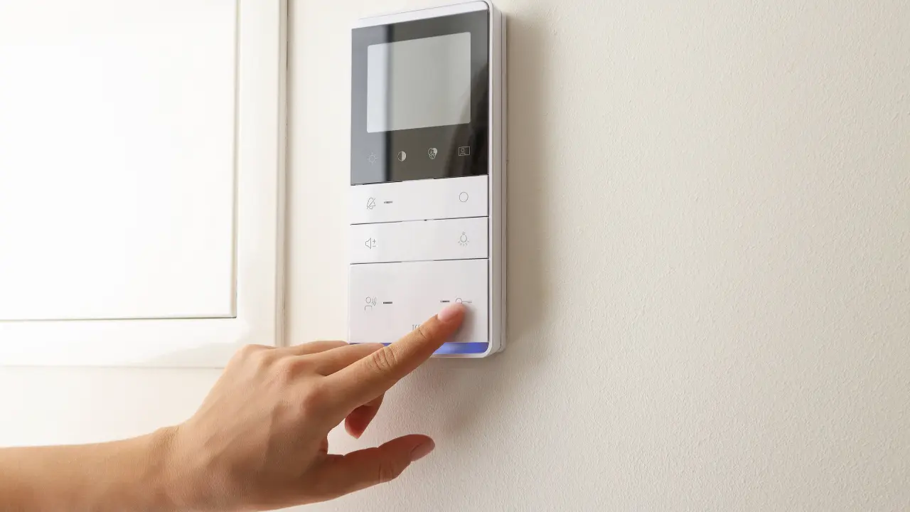 Homeowner adjusting a wall thermostat in an Elizabeth, NJ home