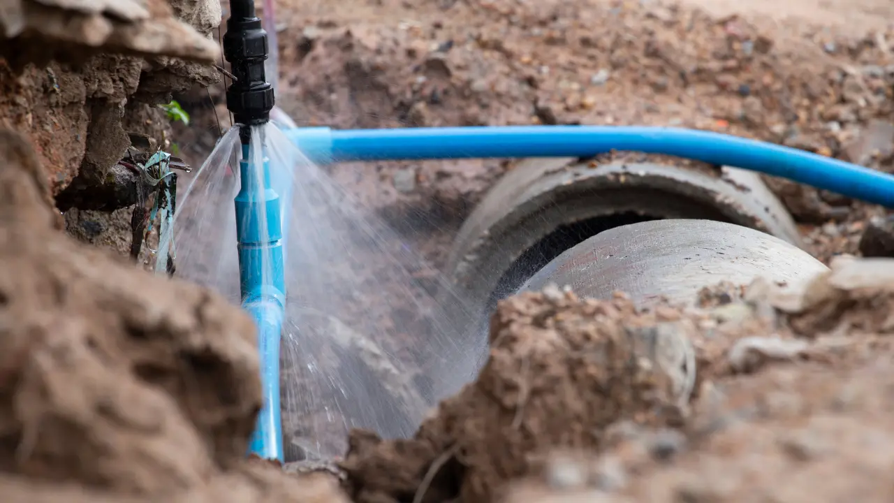 Leaking underground water line spraying at a pipe connection in Elizabeth, NJ